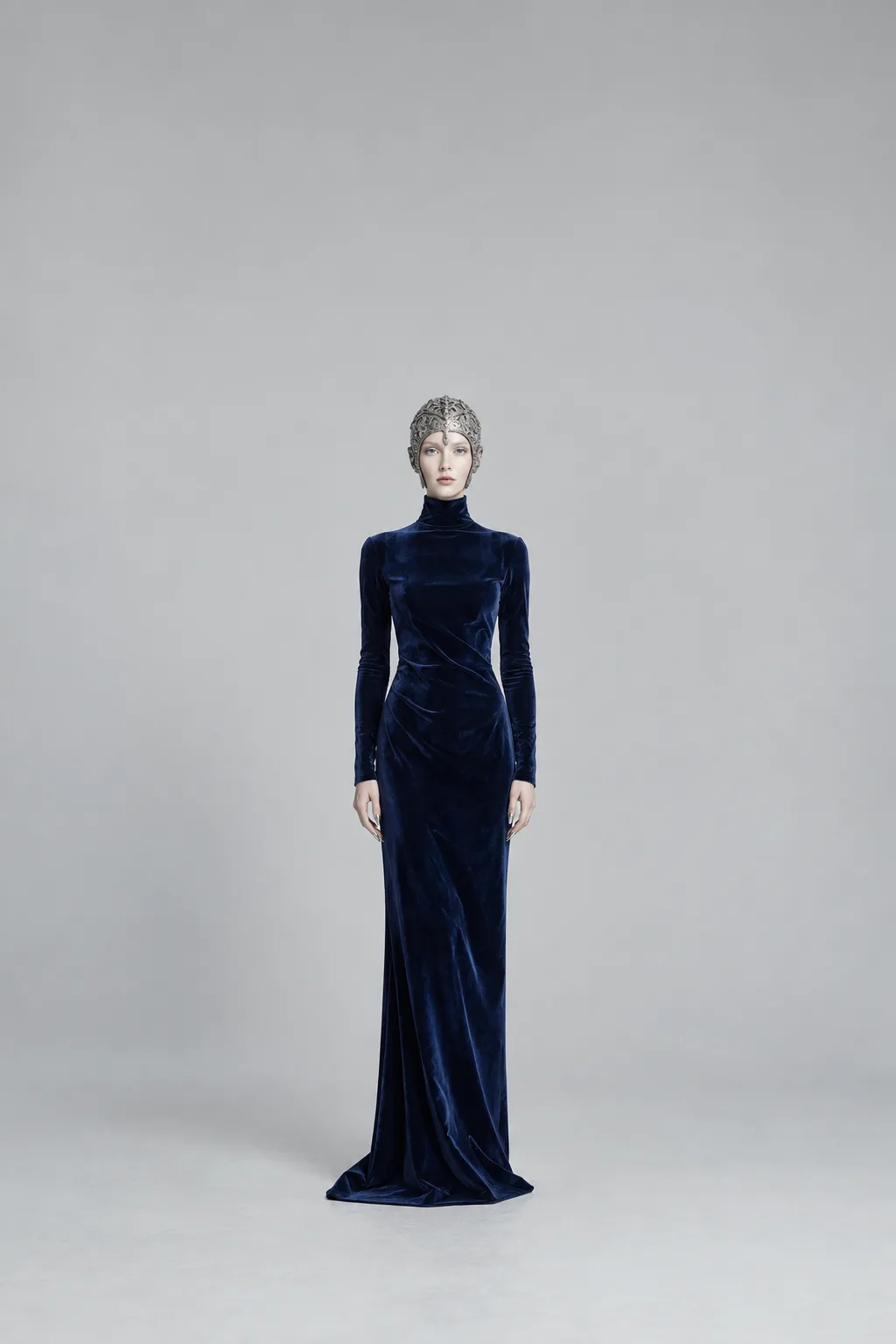 Full-length navy velvet column gown with a silver filigree helmet